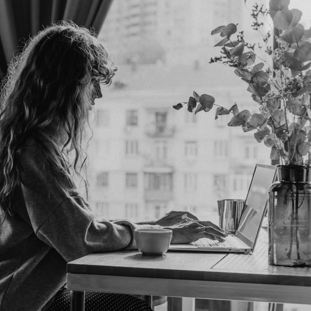 Someone studying at a laptop by a window
